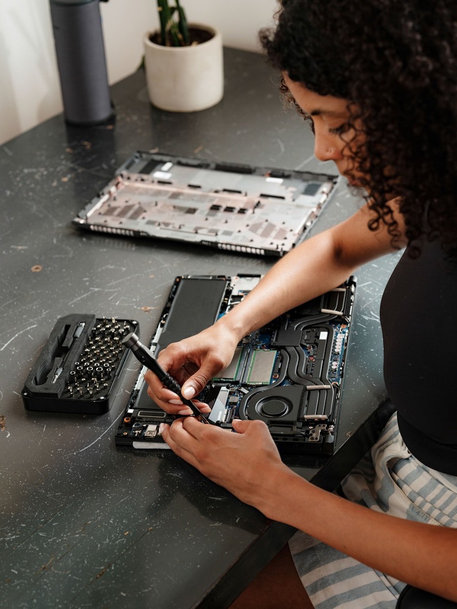 A woman sitting at a table working on a laptop